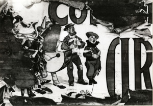 A peeling circus sign depicts several clowns playing instruments and singing. One clown holds a rabbit.