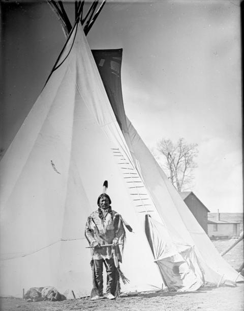 Ute Chief Buckskin Charlie poses in front of a tipi, probably in Ignacio, CO