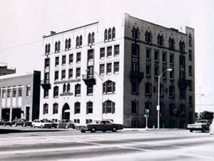 A black and white photo of the building in front of the street. 
