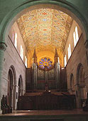A view inside the chapel with ornate ceiling and organ in the back . 