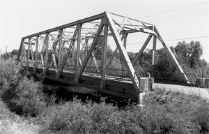 A photo of the bridge with truss from an angle in black and white.