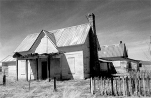 A black and white photo of the ranch with gable roof buildings in a line going to the right.