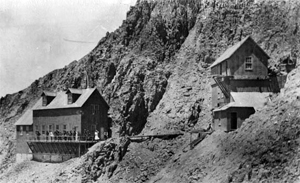 A black and white photo of the two buildings on either side of the mountain. 