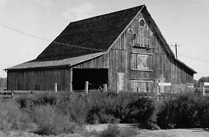 A photo of the barn with bonnet roof in black and white.