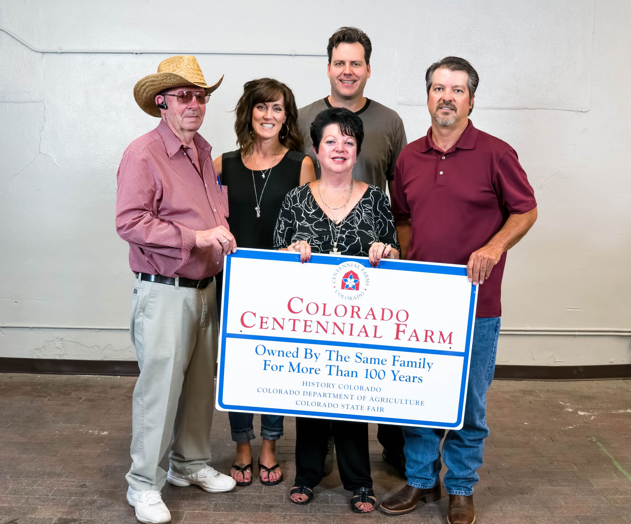 The Carpenter-Newbanks Farms family with their Centennial Farms sign.