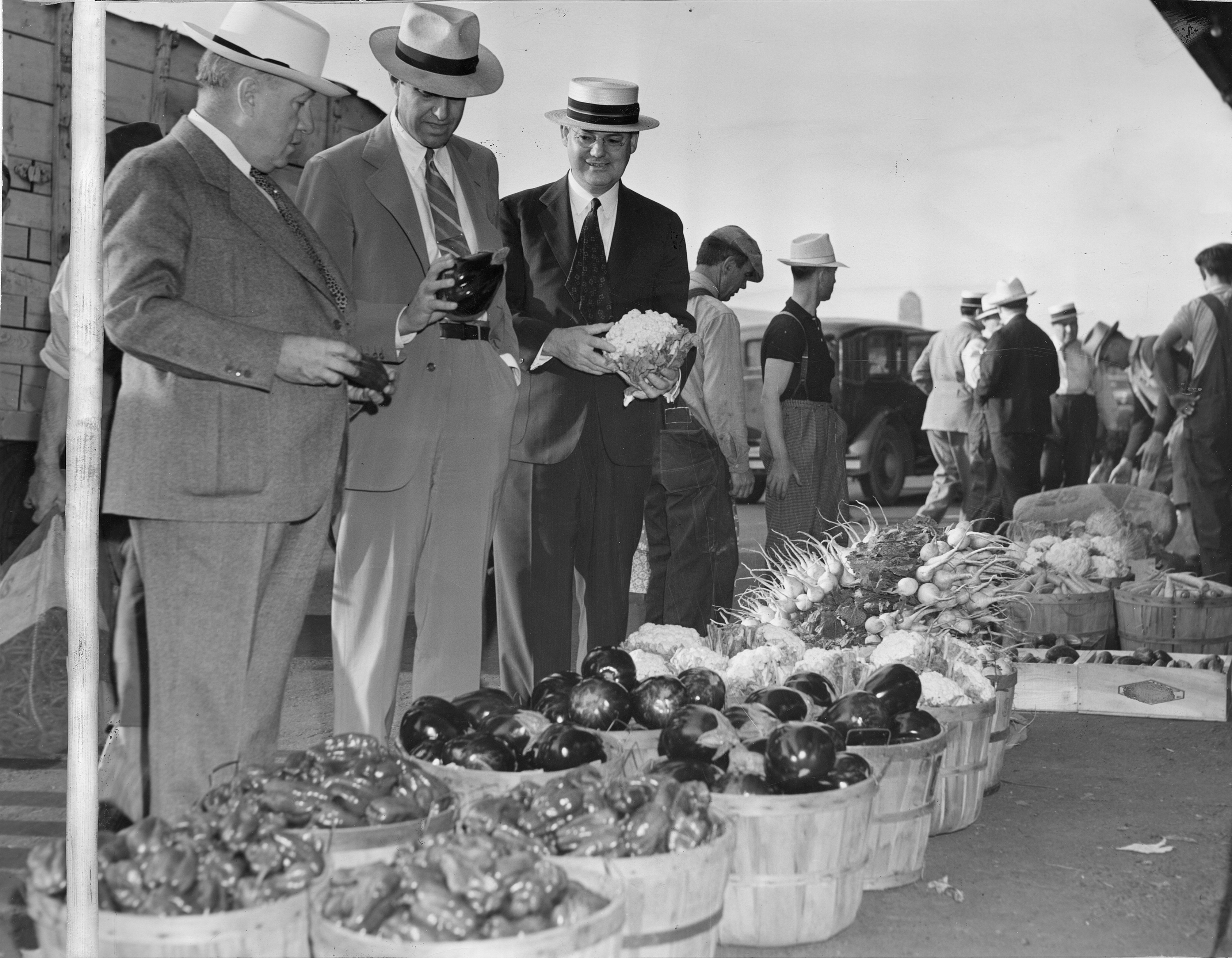 men at market with baskets of produce