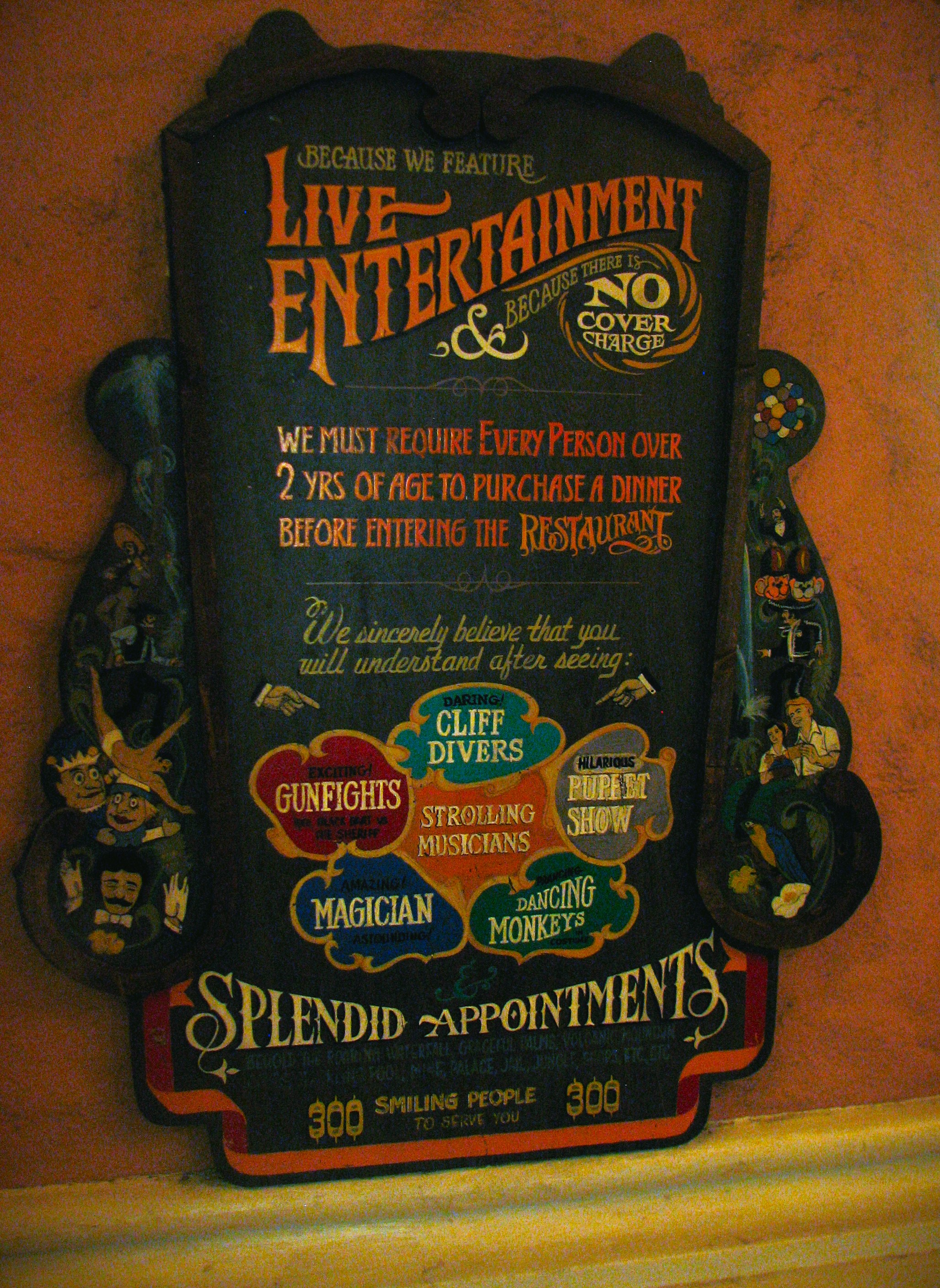 Casa Bonita Entrance Sign, reading "Because we feature live Entertainment, and because there is No Cover Charge, we must require every person over 2 years of age to purchase a dinner before entering the restaurant. We sincerely believe that you will understand after seeing: Dangerous Gunfights, daring Cliff Drivers, hilarious Puppet Shows, astounding Magicians, Dancing Monkeys, and Splendid Appointments."