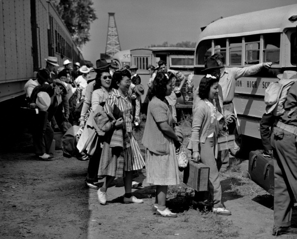 New arrivals disembarking from the train onto school buses waiting to take them to Amache.