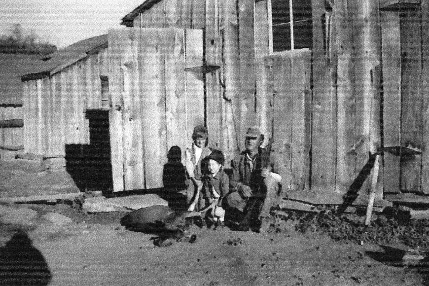 Clarence Everett and his two daughters outside the south barn with a deer carcass.