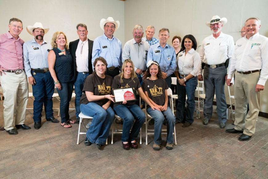 Bar 7T Ranch family (seated) with their certificate.