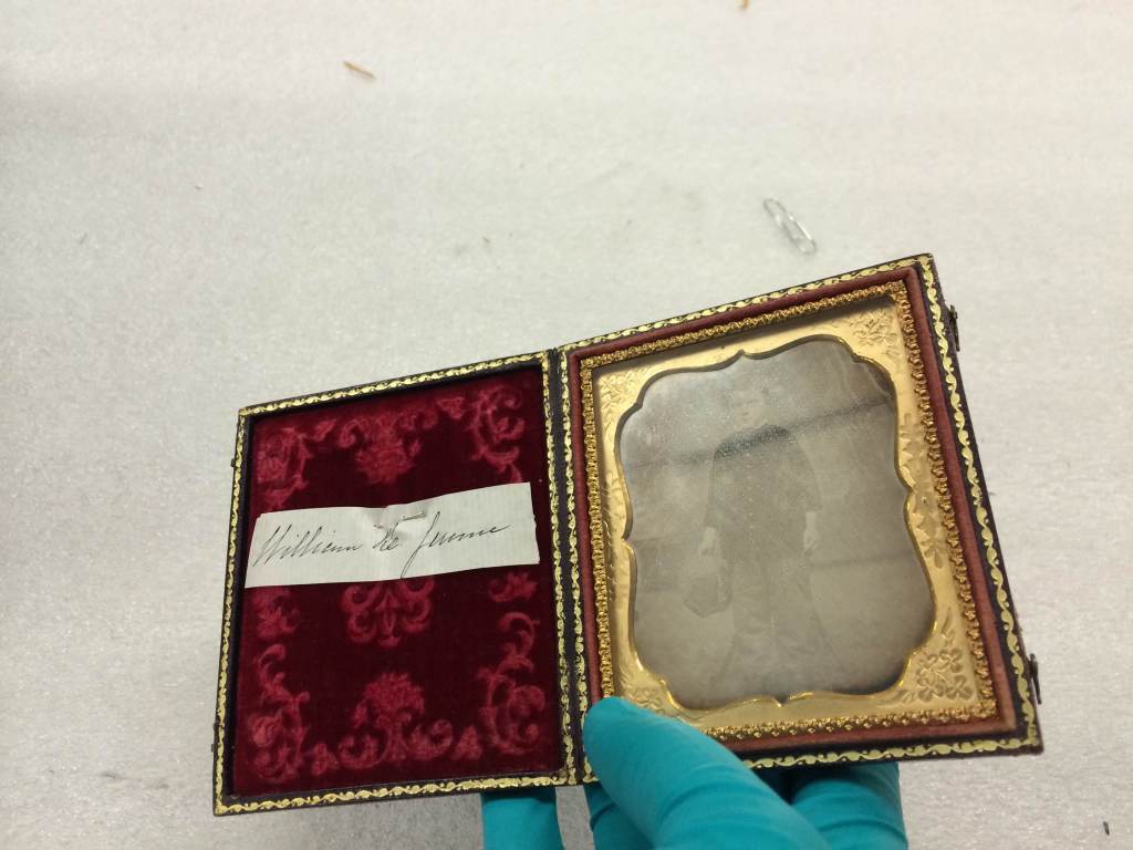 Daguerreotype being held by a rubber-gloved hand