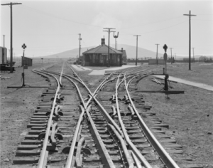 Historic photograph of the Denver & Rio Grande Antonito Depot with railroad tracks in the foreground.