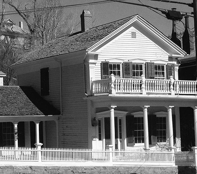 Black and white photo of a Greek Revival style home.
