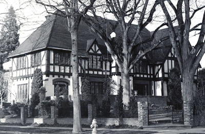 Black and white photo of a Tudor Revival style home.