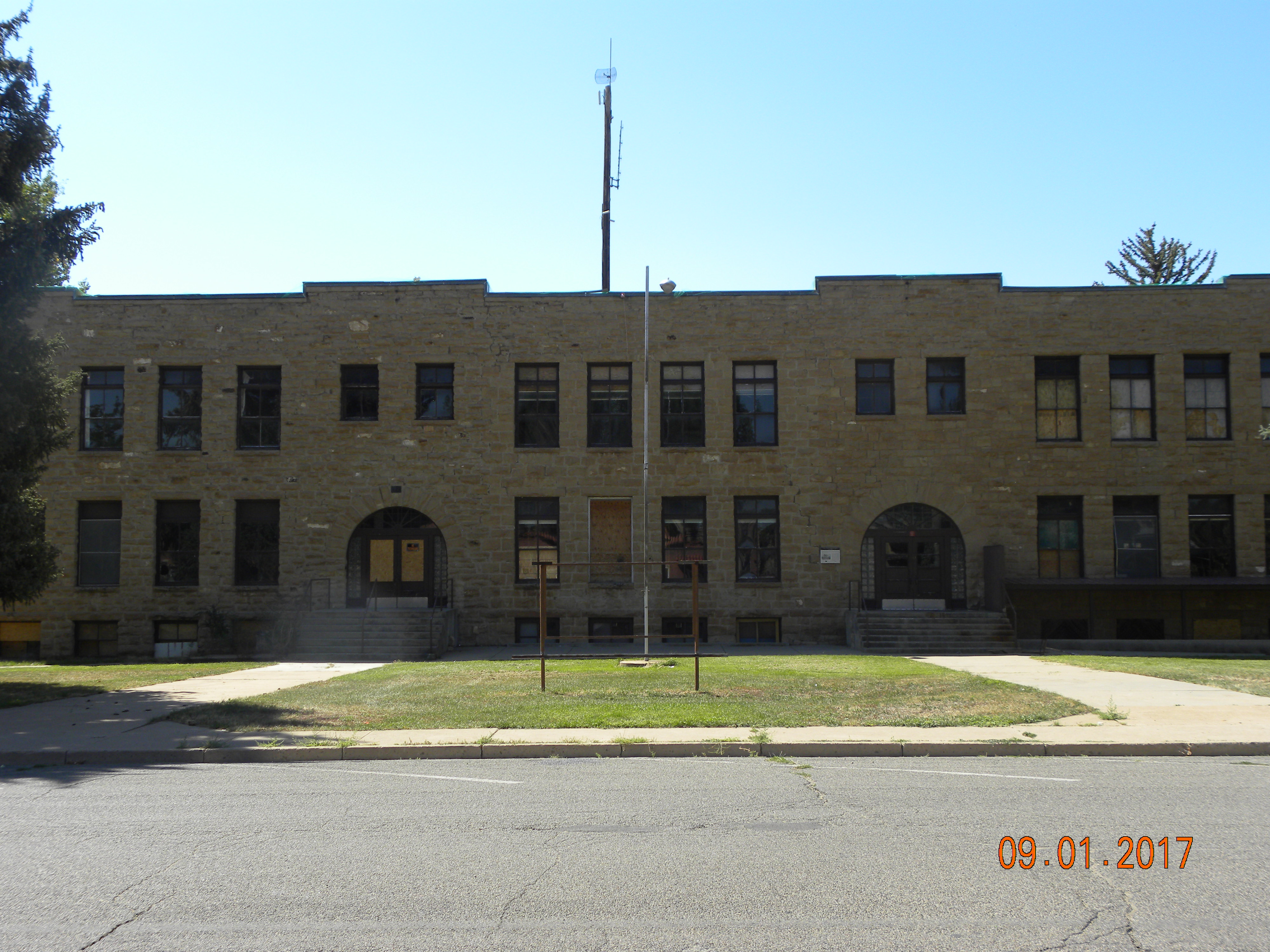 Calkins School, a two-story stone school building with two arched entryways.
