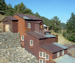 A photo of the mill, running down the incline with sloping windows and white-trimmed windows. 