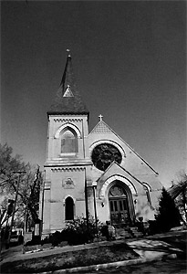 A black and white photo looking up at the church 