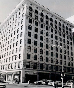A black and white photo of the building with rows of windows and a lamppost in the foreground.