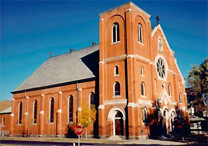 A photo of the church with the steeple casting a shadow on the roof. 