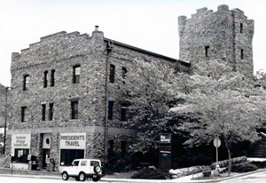 A black and white photo of the building with large tower in the rear. 
