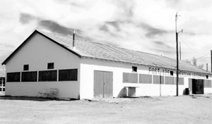 A black and white photo of the hall with white walls, large horizontal windows and gable roof. 