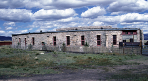 A picture of the building with stone walls and tall windows.
