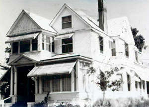 A black and white photo of the house with multiple gables. 