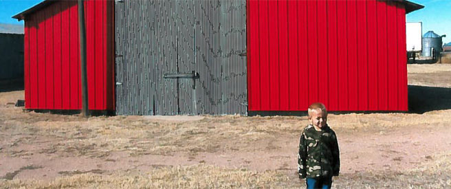 Barn at Fast Heritage Farm with small boy in the foreground.