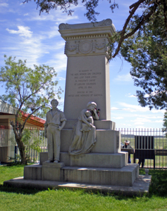 A picture of a monolithic monument with statues in front.