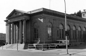 A black and white photo of the post office with pediment supported by pillars and arched roofs. 
