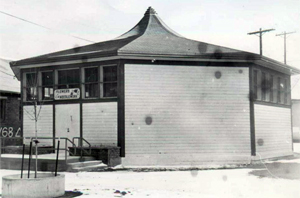 A black and white photo of the building with a octagonal ogee roof and alternating sides with windows. 