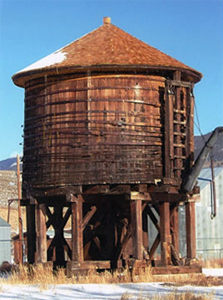 A view of the tank with round wooden walls atop support beams and beneath a conical roof.