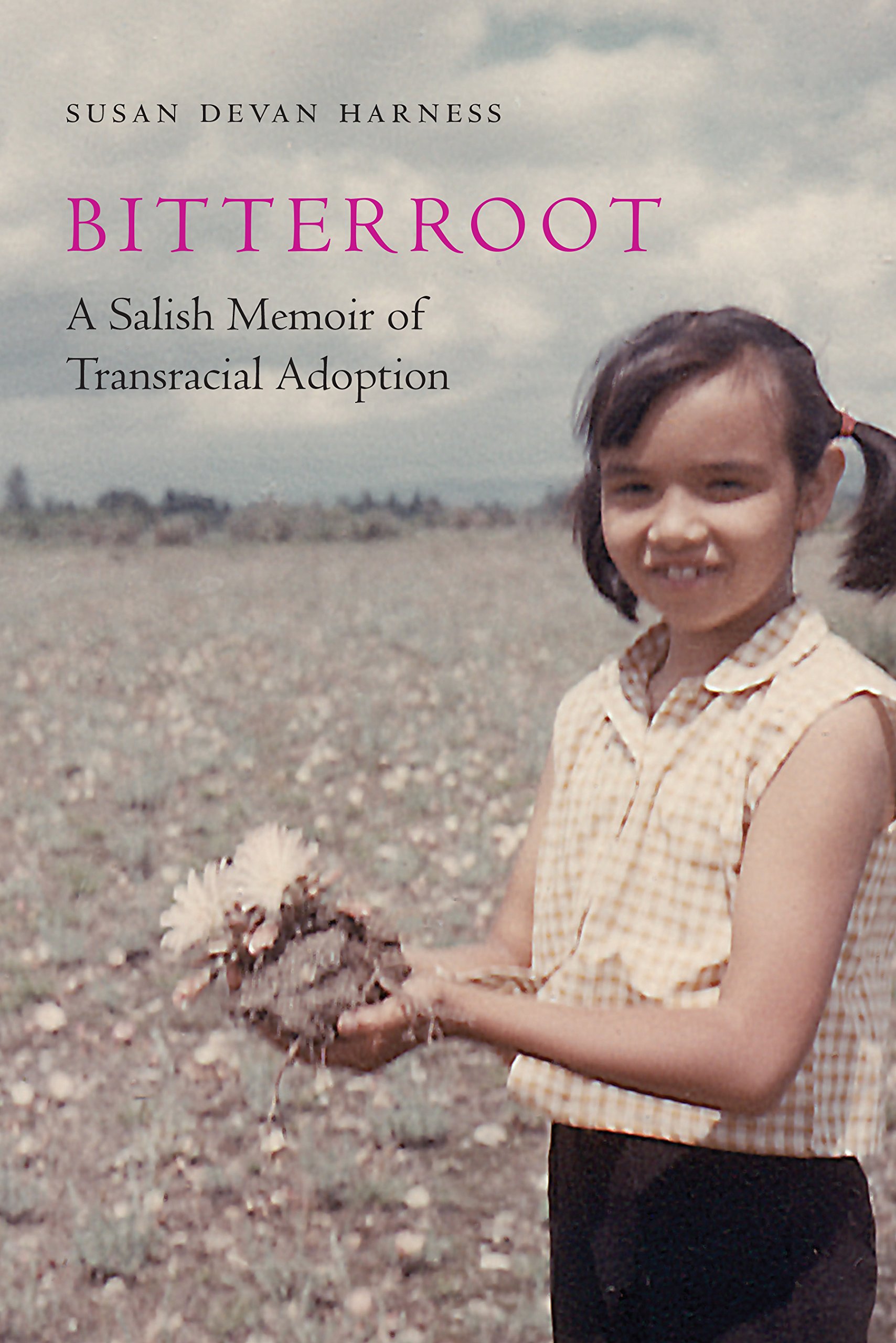 Image of the cover of the book, Bitterroot by Susan Devan Harness. The cover shows a photo of a young girl with two pony tails, a sleeveless gingham shirt, and a handful of soil and flowers. She is smiling at the person taking the photo. She is surrounded by flat grasslands.