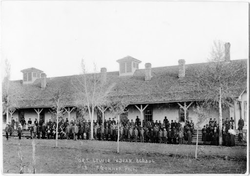 Photo of students standing lined up in front of the Fort Lewis Indian School.