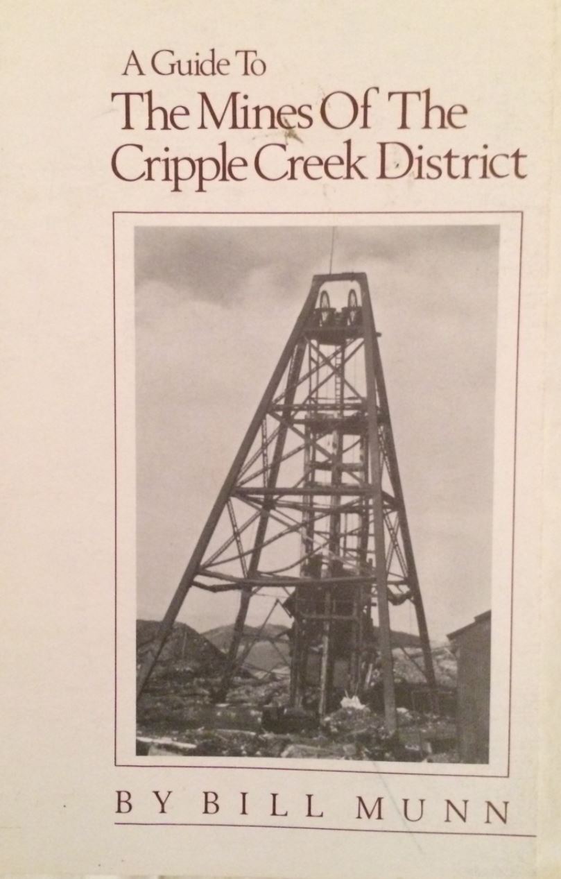 Image of book cover, A Guide to the Mines of the Cripple Creek District by Bill Munn. The cover is simple in design, with a single image of a wooden mine shaft structure in the center of the cover. The cover itself is of a rosy linen color, and the title and author's name are printed at the top and bottom of the page, respectively,in a maroon colored ink.