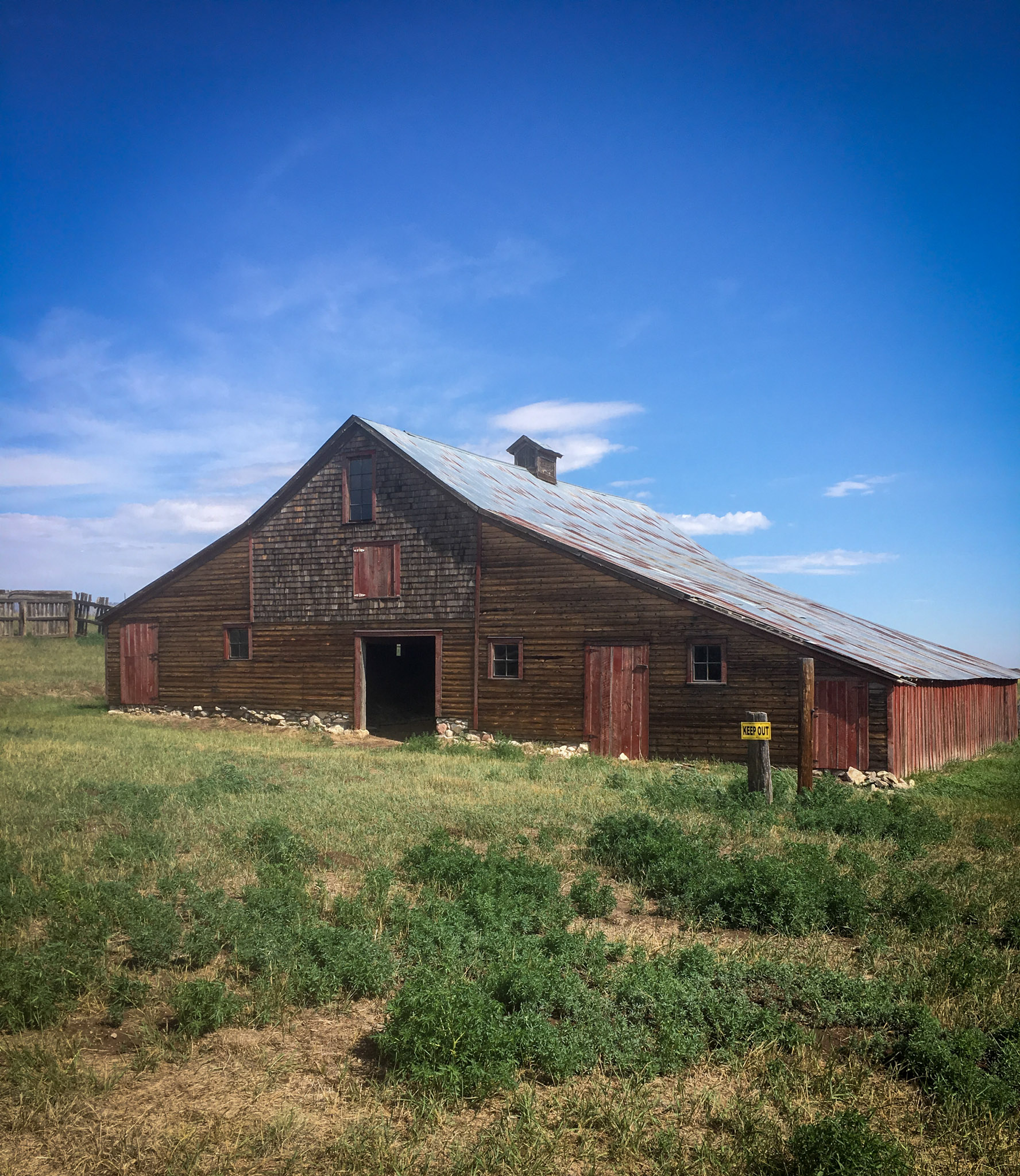 Front view of a historic red barn on a summer day.