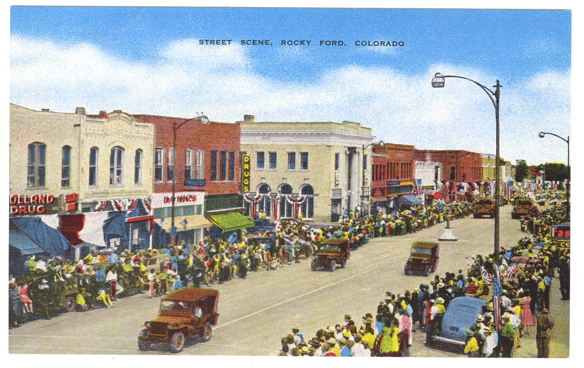 Image of a historic postcard showing a Fair Day parade in the 1940s in Rocky Ford, Colorado. Colorful crowds of spectators line the streets as jeeps roll by. Buildings are decorated in red, white, and blue banners and half-round buntings. American flags are also on display.