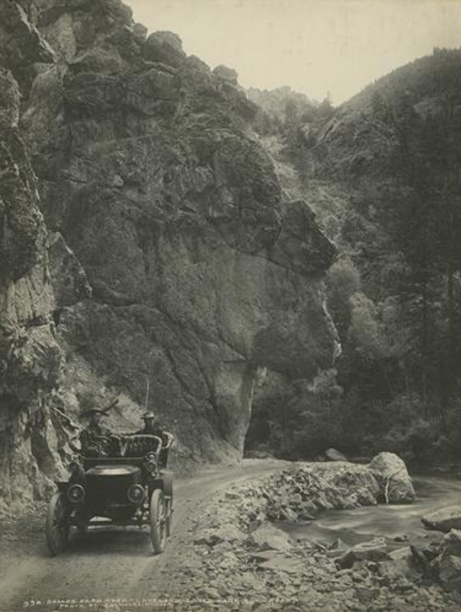 An early automobile driving down the Estes park River Road.