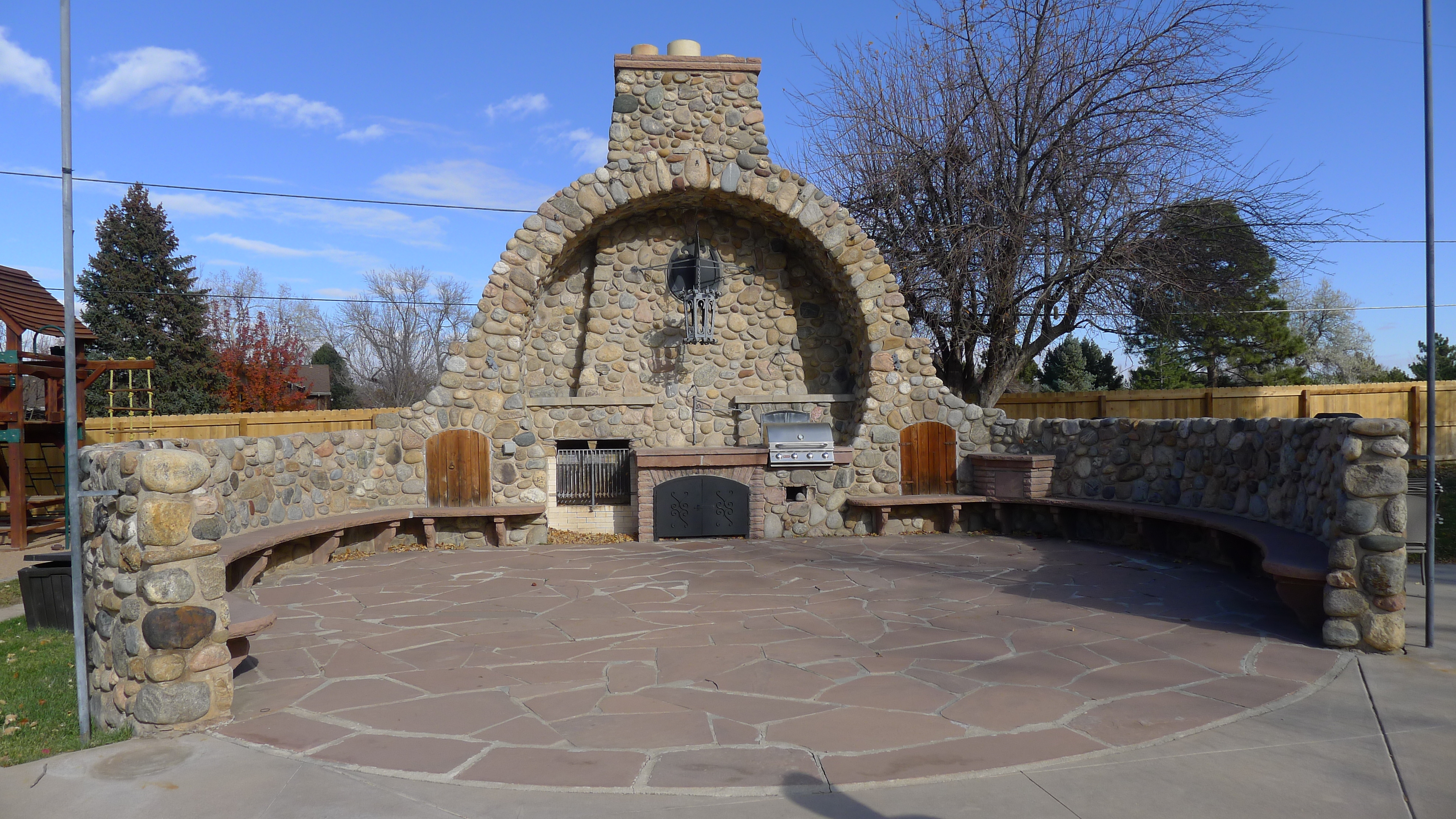 An outdoor kitchen with an unusual semi-circular shape. The kitchen is made out of stones.