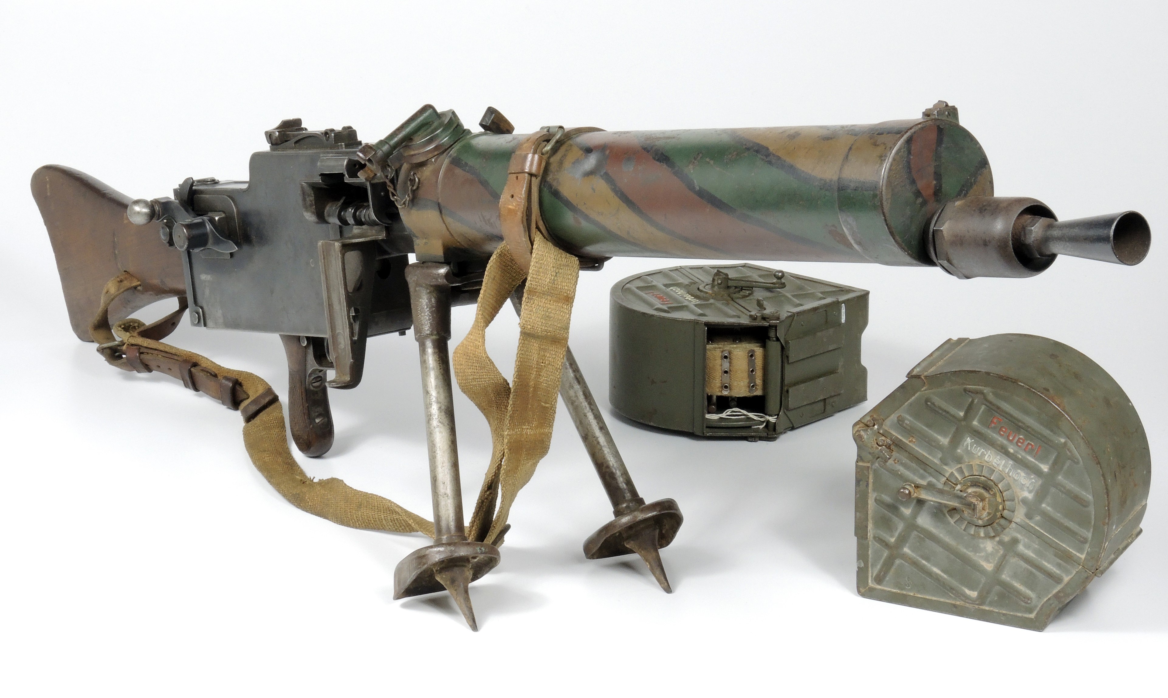 Photo of an Imperial German Model 1908/15 Maxim light machine gun and associated components including two round ammunition boxes with independent feed belts, a bi-pod support, an extra main spring, and an extra barrel.