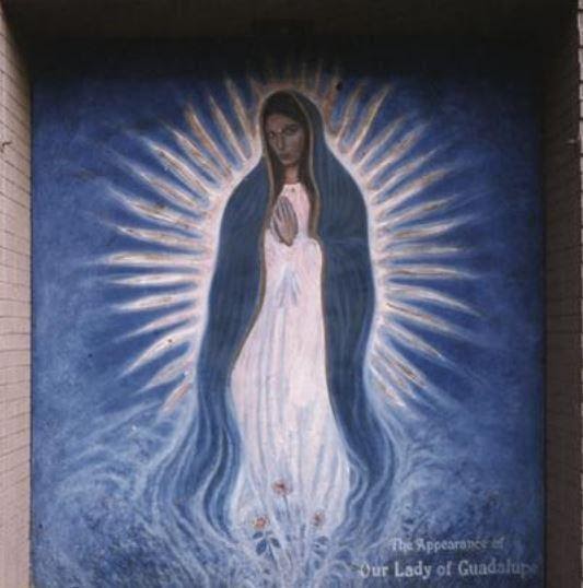 A mural depicting the appearance of Our Lady of Guadalupe, in shades of blue and white.
