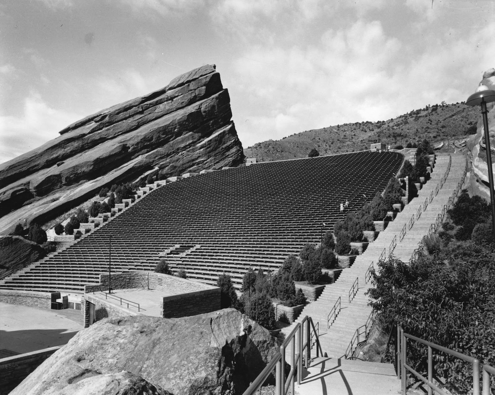 A black and white photo of Red Rocks Amphitheater, with the seating rising up among the rocks.