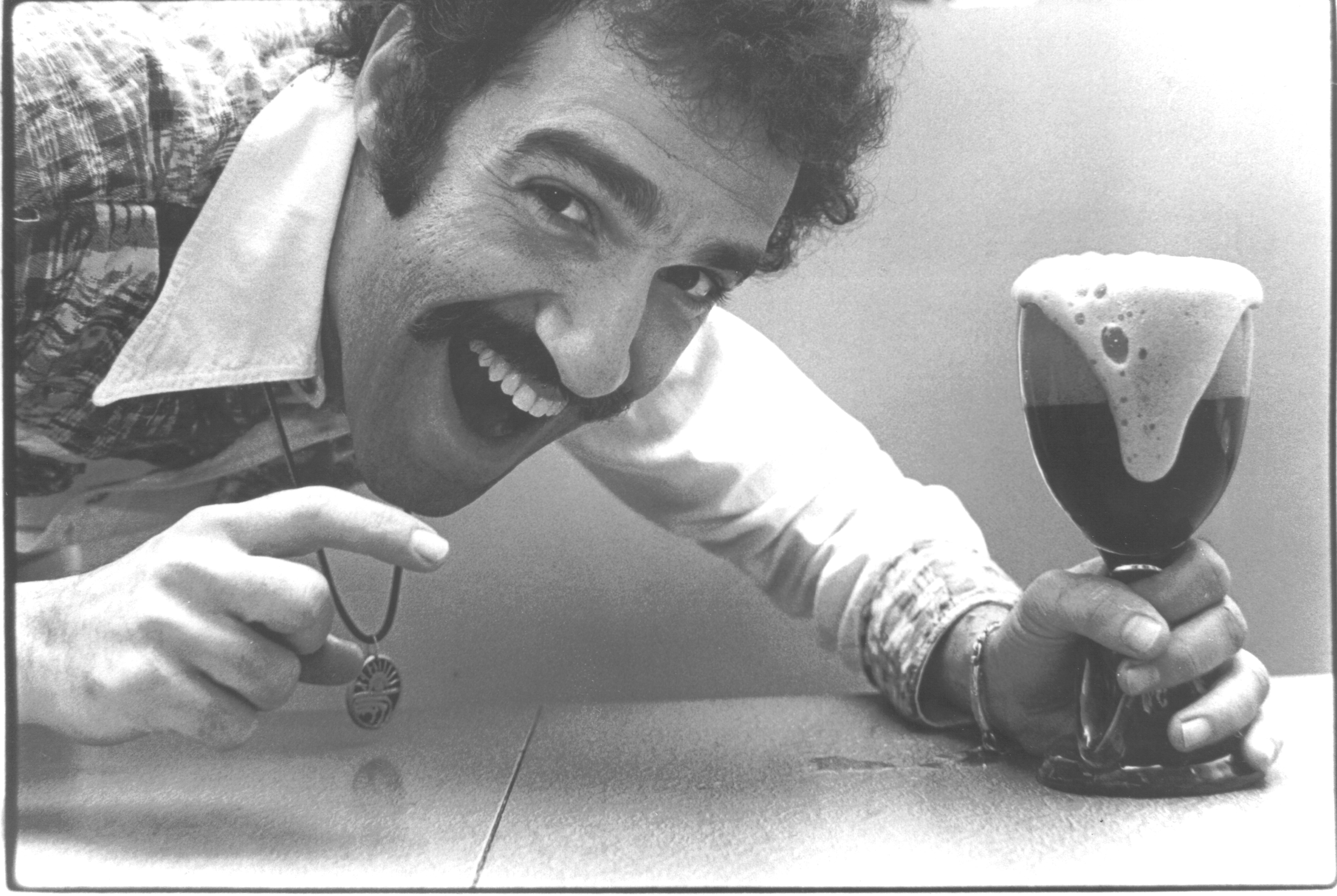 Charles Papazian posing with a glass of beer.
