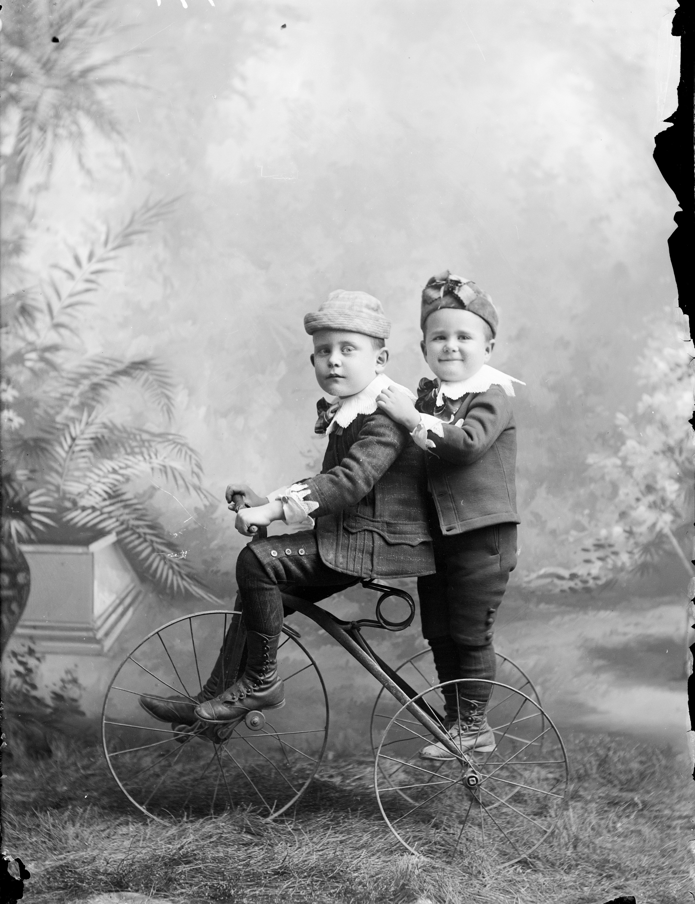 Children posing on a bicycle in a photo studio