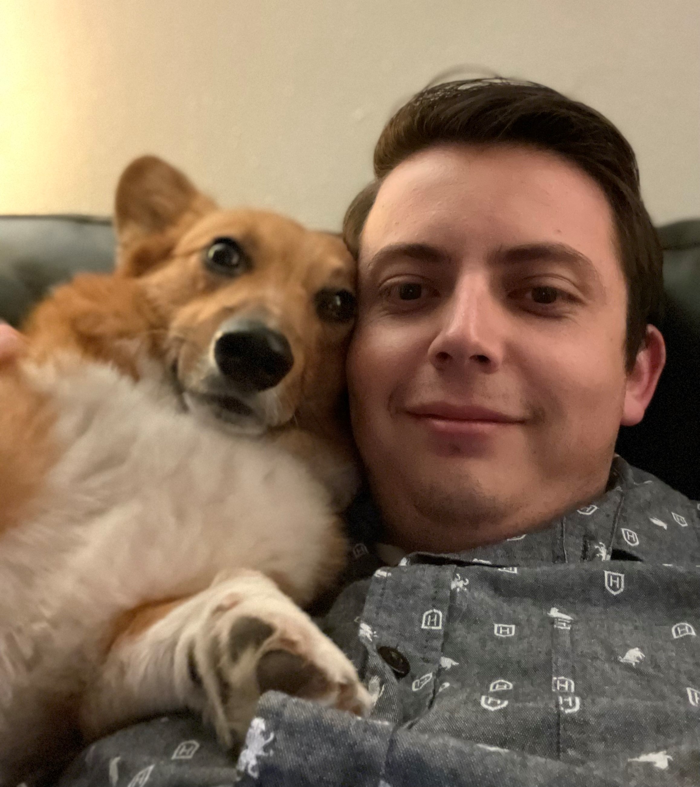 Photo of a tan and white Pembroke Welsh Corgi named Winston. He is pictured here in a selfie with his owner, their heads together and they are both smiling! 