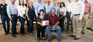 Carpenter-Newbanks Farms family members (seated) with their certificate.