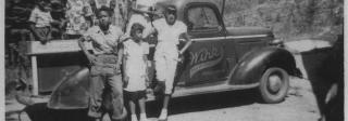 Children stand in and in front of a “Winks Mountain Cabins” pickup truck in the 1950s