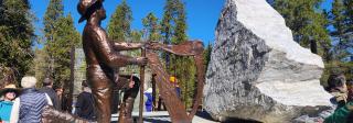 A perspective of the centerpiece of the Leadville Miners' Memorial, which depicts a man with a pick, kneeling at an Irish harp.