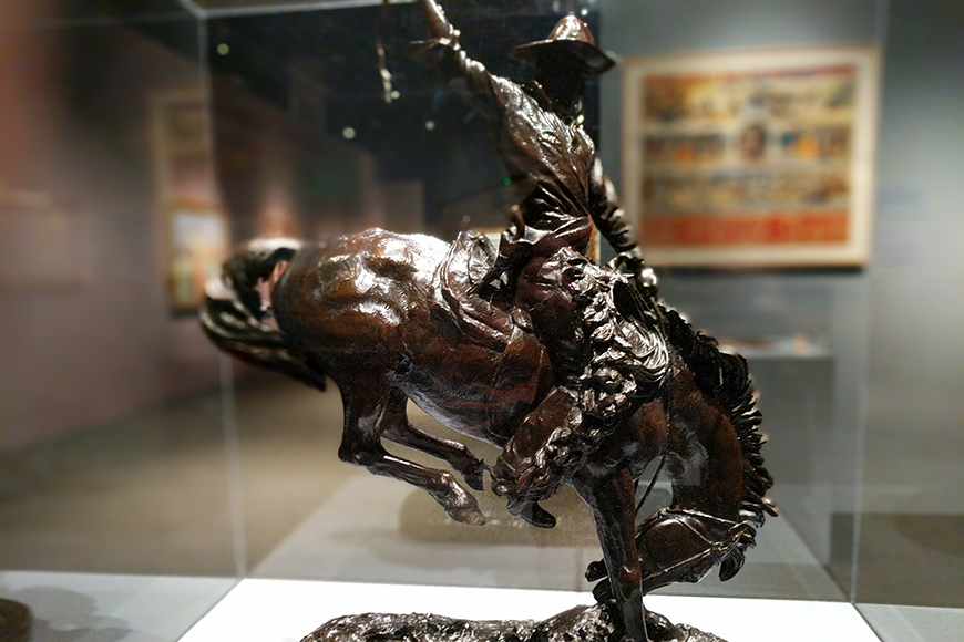 A bucking horse sculpture in a display case.