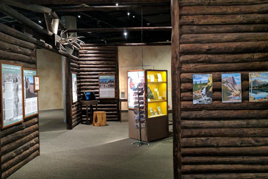 Side image of RMNP showing display cases and log cabin walls. 